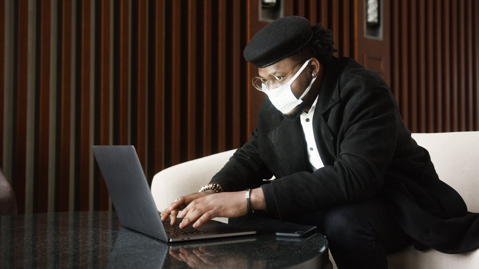 woman in black coat using black laptop computer